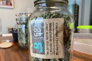 Mason jar filled with cannabis buds and a Boveda humidity control pack for curing and freshness.