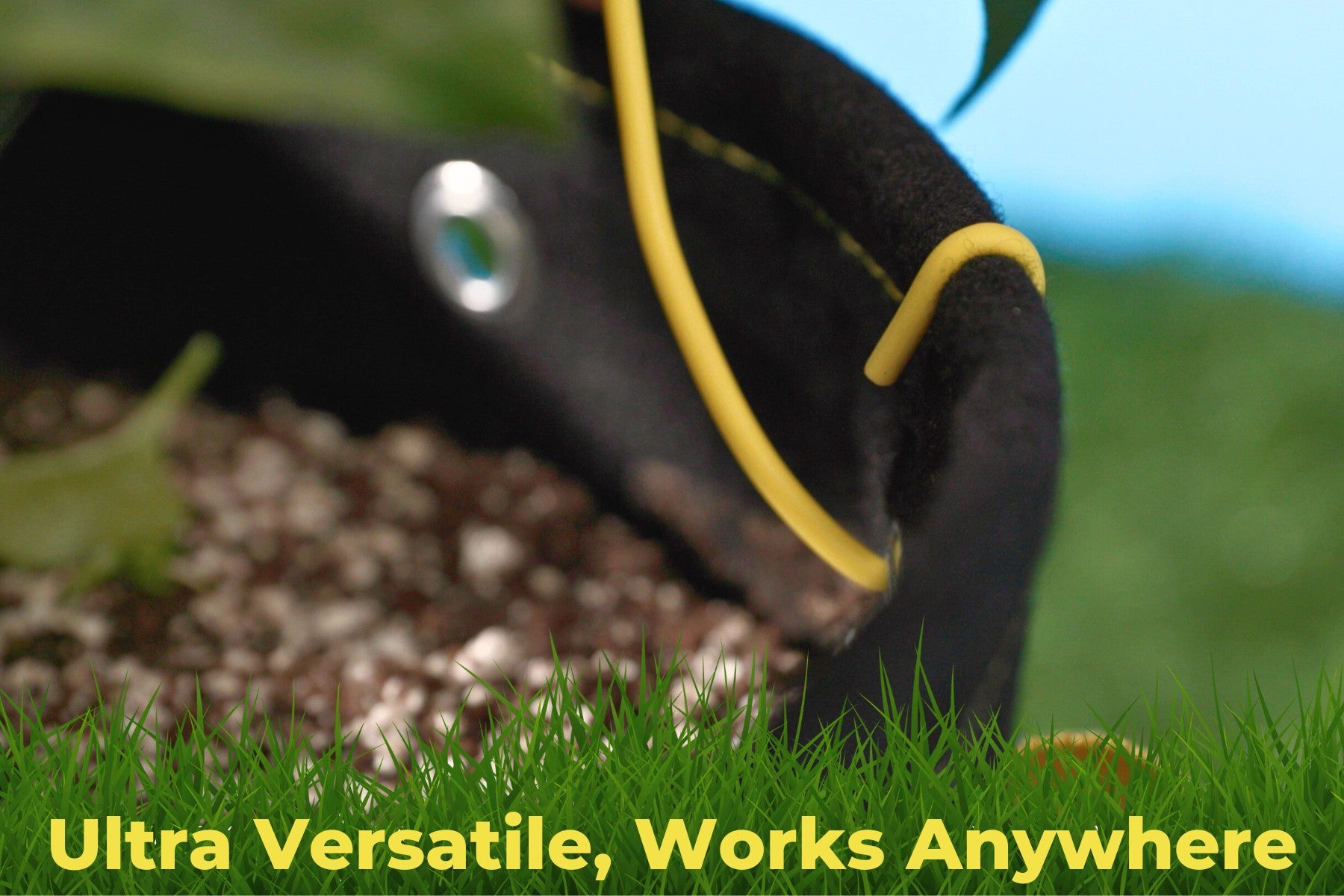 Close-up of yellow BudHuggers training wire attached to grow bag, showing secure and versatile usage in soil.
