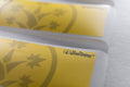 Close-up of BudTrainer yellow sticky notes with logo for cannabis grow tracking and reminders.