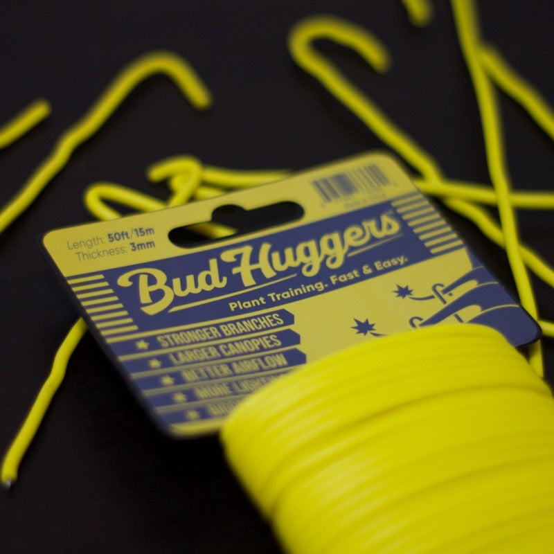 BudHuggers yellow garden wire 50ft on a black top with BudHuggers pieces around